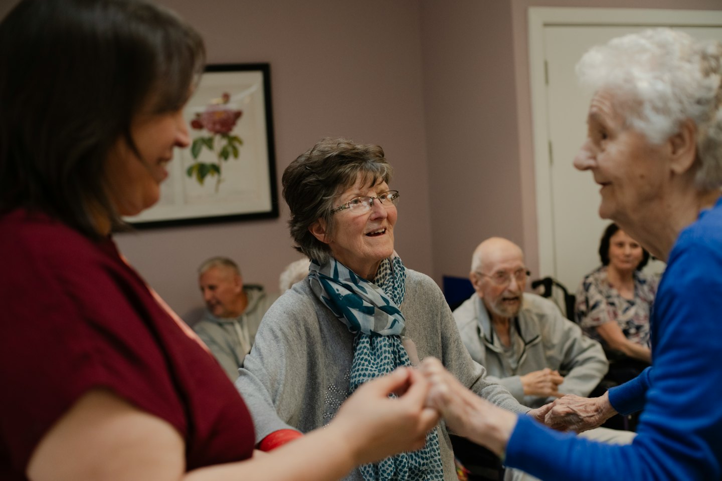 Women holding hands and smiling during a group activity.