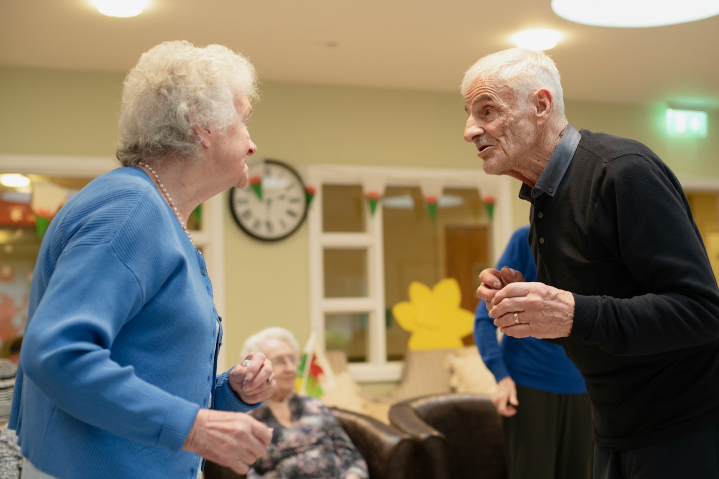 Elderly couple dancing in a community room.
